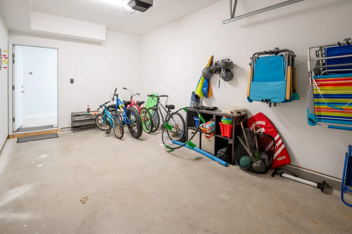 An interior storage area featuring bicycles, beach equipment, and storage bins, suggesting easy access to outdoor adventure. The setup speaks to group outings, like bike rides or beach days, with all the gear ready for use.